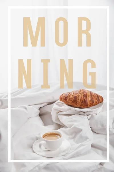 Fresh croissant on plate near coffee in white cup on saucer in bed with morning illustration — Stock Photo