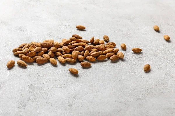 Deliciosas almendras frescas en superficie texturizada gris, menú dietético cetogénico - foto de stock