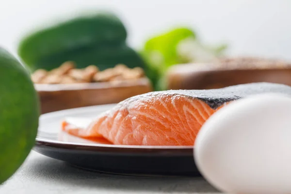 Selective focus of fresh raw salmon on white plate, ketogenic diet menu — Stock Photo