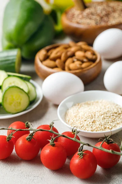 Selective focus of fresh tomatoes near ketogenic diet ingredients — Stock Photo