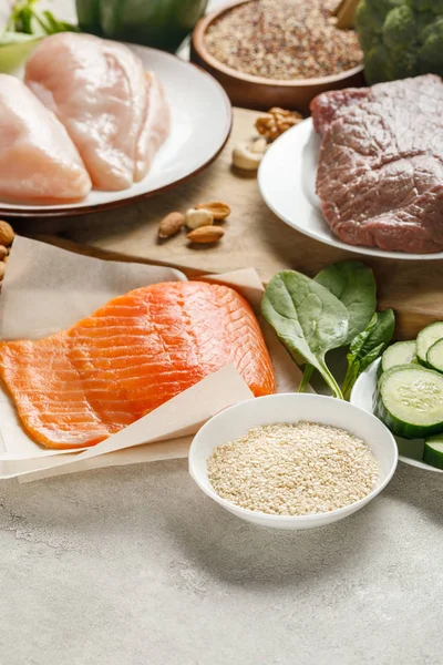 Frischer roher Lachs, Hühnerbrust und Fleisch in der Nähe von Nüssen, Spinat, Gurken und Grütze, ketogene Diät-Menü — Stockfoto