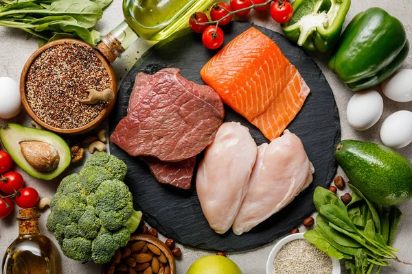 Vista superior de la carne cruda y el pescado entre verduras frescas, menú de dieta cetogénica - foto de stock