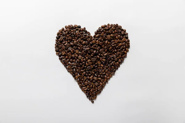 Top view of  heart made of fresh coffee grains on white background — Stock Photo
