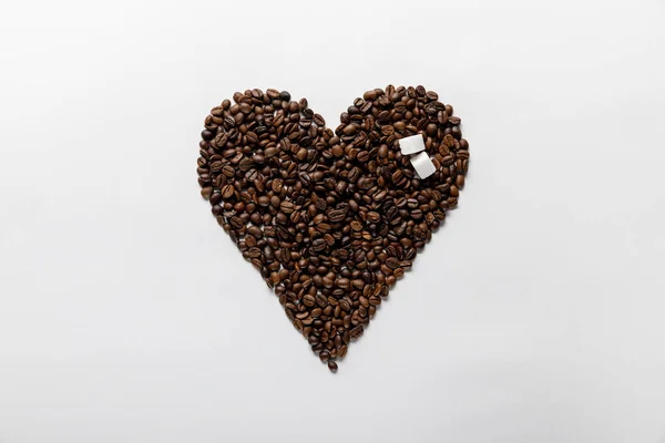 Top view of heart made of coffee grains with sugar on white background — Stock Photo