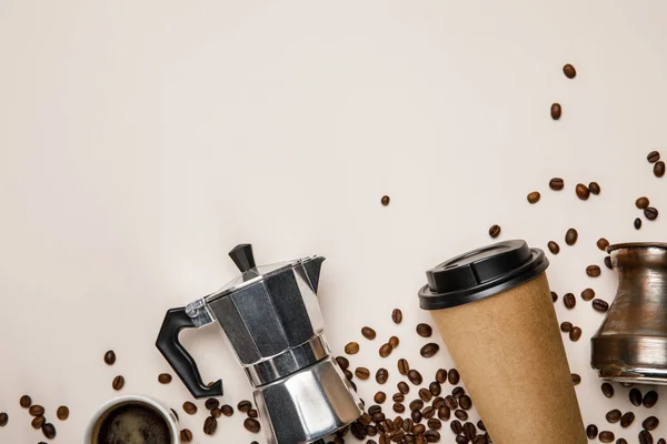 Vista superior de cezve, panela de café, xícara de papel e grãos de café no fundo bege — Fotografia de Stock