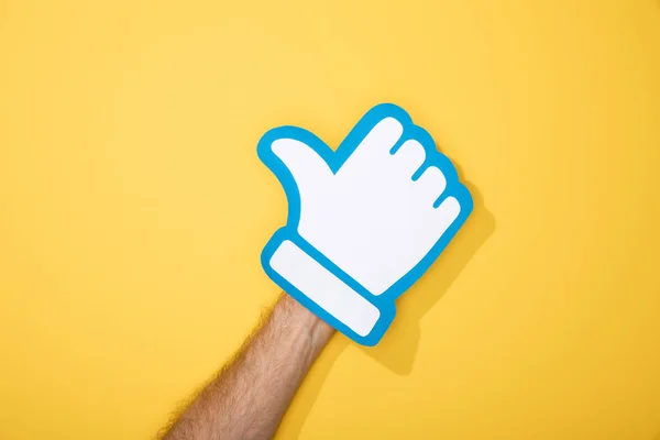 Cropped view of man with white paper thumb up on yellow — Stock Photo