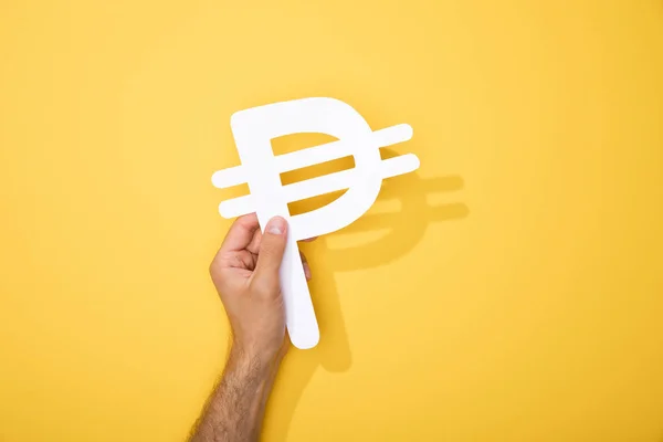 Cropped view of man holding paper peso currency signs on yellow — Stock Photo