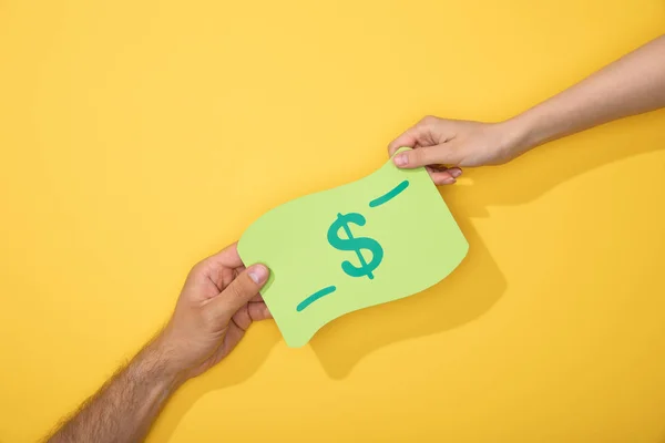 Abgeschnittene Ansicht von Mann und Frau mit Papiersymbol der Dollarnote auf gelbem Hintergrund — Stockfoto