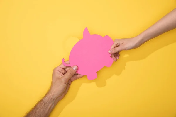 Ausgeschnittene Ansicht von Mann und Frau mit Papiersparschwein auf gelb — Stockfoto