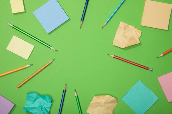 Vue de dessus des crayons éparpillés et du papier avec espace vide dedans, ralenti — Photo de stock