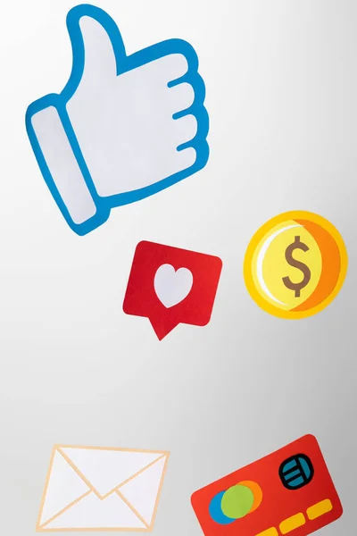 Papiersymbole mit Umschlag, Münze, Kreditkarte, Herzen und Daumen nach oben auf weißem Hintergrund — Stockfoto