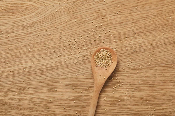 Top view of white quinoa in wooden spoon on table — Stock Photo