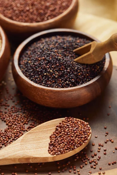 Vista de perto de quinoa preto e vermelho em tigela de madeira com espátula perto da colher — Fotografia de Stock