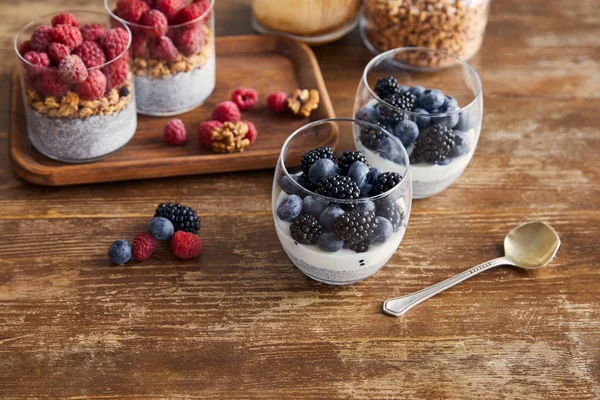 Breakfast with oat flakes, yogurt with chia seeds and berries on wooden tray on table — Stock Photo