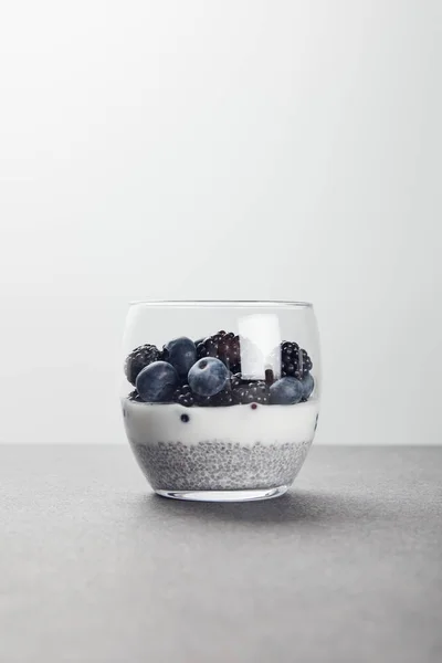 Tasty yogurt with chia seeds, blueberries and blackberries on marble surface isolated on grey — Stock Photo