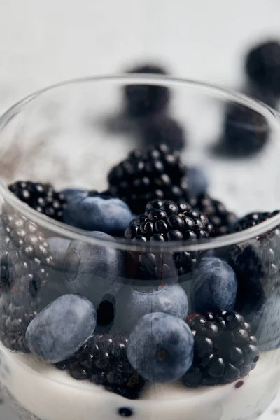 Close up view of blackberries, blueberries and yogurt in glass — Stock Photo