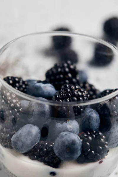 Vista de cerca de moras, arándanos y yogur en vidrio - foto de stock