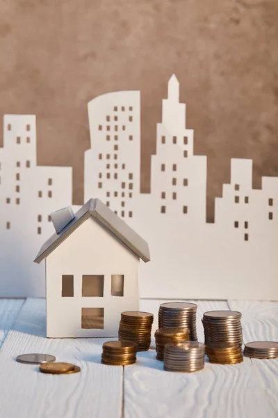 Häuser Modelle auf weißem Holztisch mit Münzen, Immobilienkonzept — Stockfoto