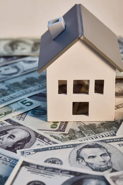 Modelo de casa en billetes de dólar, concepto de bienes raíces - foto de stock