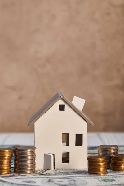 Modèle de maison sur les billets de banque en dollars près de pièces, concept immobilier — Photo de stock