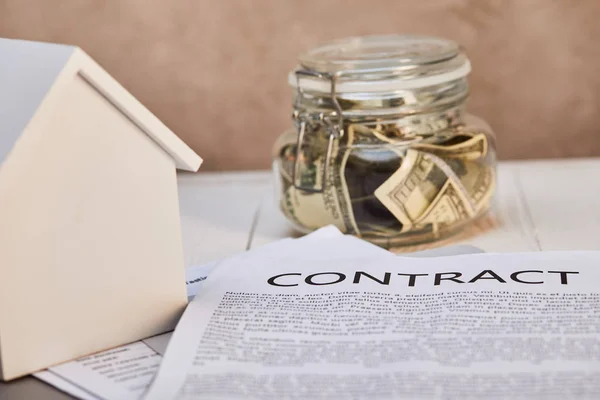 House model on white wooden table with contract and moneybox, real estate concept — Stock Photo