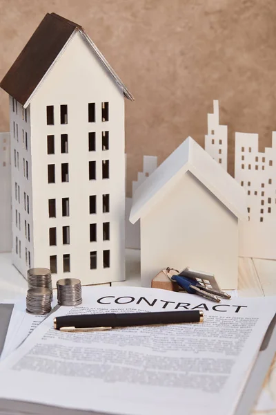 Maisons modèles sur table en bois blanc avec contrat, clés et pièces, concept immobilier — Photo de stock