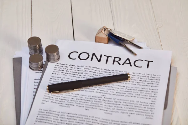 Contract, pen, coins and keys on white wooden table, real estate concept — Stock Photo