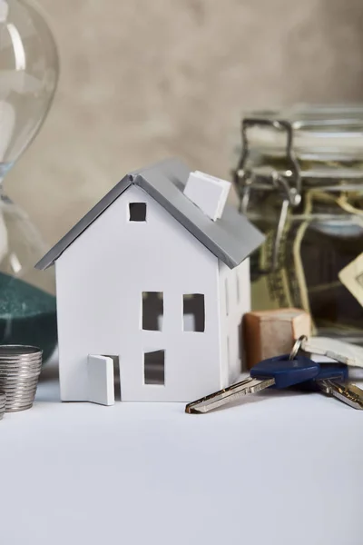 Modelo de casa en mesa blanca con llaves, concepto de bienes raíces - foto de stock