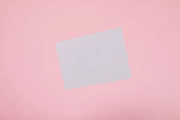 Top view of blank white card on pink background — Stock Photo