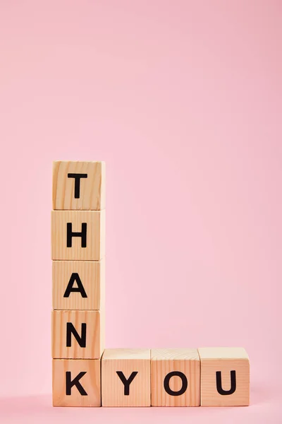 Cubos de madera con letras de agradecimiento sobre fondo rosa con espacio de copia - foto de stock