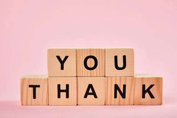 Wooden blocks with thank you words on pink background with copy space — Stock Photo