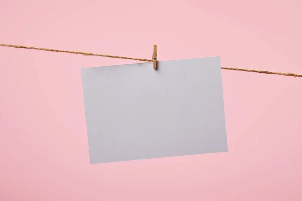 Cartão branco vazio pendurado na corda isolada no rosa — Fotografia de Stock