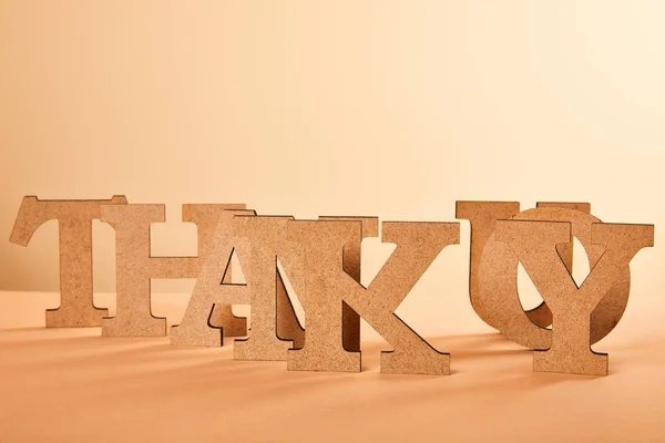Paper cut thank you lettering on table isolated on beige — Stock Photo