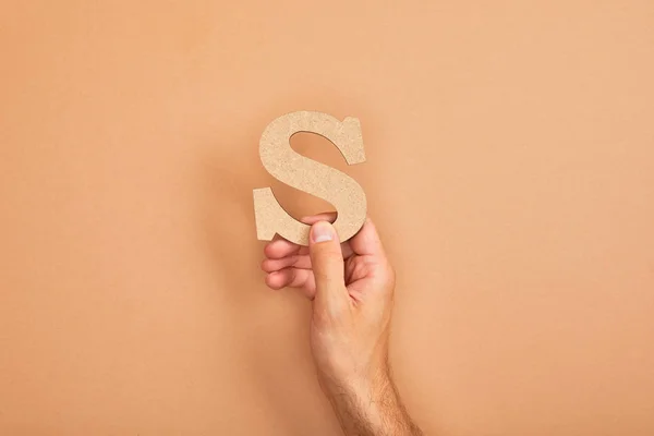 Cropped view of man holding paper cut letter S on beige background — Stock Photo