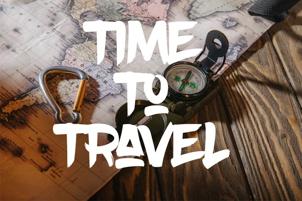 Compass, safety hook and map on wooden table with time to travel illustration — Stock Photo