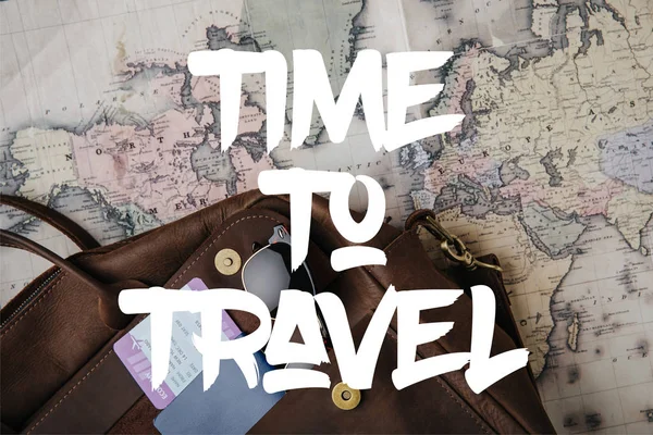 Vista superior de la bolsa de cuero con pasaporte, billete, gafas de sol y mapa con tiempo para viajar ilustración - foto de stock