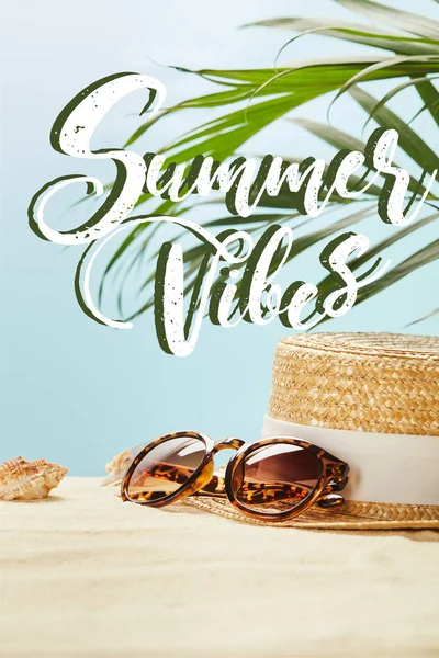 Gafas de sol cerca de sombrero de paja y conchas marinas en verano aislado en azul con vibraciones de verano ilustración - foto de stock