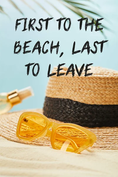 Gafas de sol cerca de sombrero de paja y botella con aceite bronceador en la playa de arena aislado en azul con el primero a la playa, último en dejar ilustración - foto de stock