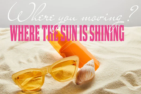 Gafas de sol con estilo amarillo y protector solar en botella de color naranja sobre arena con concha de mar sobre fondo gris con donde se mueve la pregunta y donde el sol está brillando respuesta - foto de stock