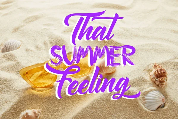 Occhiali da sole giallo elegante sulla sabbia con conchiglie e quella sensazione di estate lettering — Foto stock