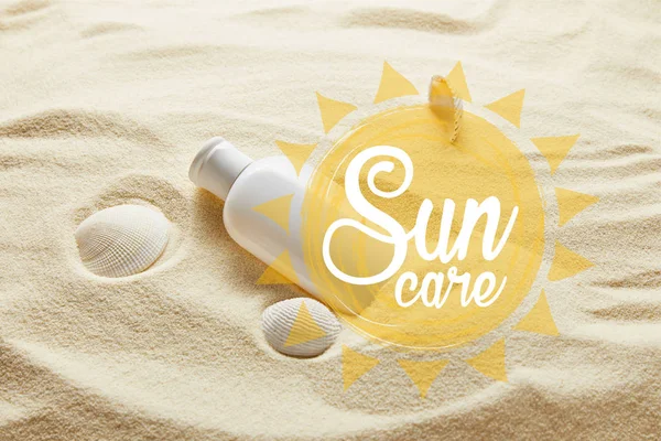 Sunscreen in white bottle on sand with seashells and sun care lettering — Stock Photo