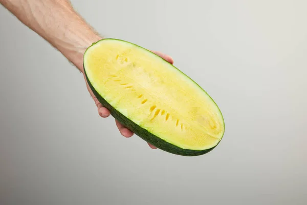 Abgeschnittene Ansicht des Mannes mit reifer gelber Wassermelone halb isoliert auf grau — Stockfoto