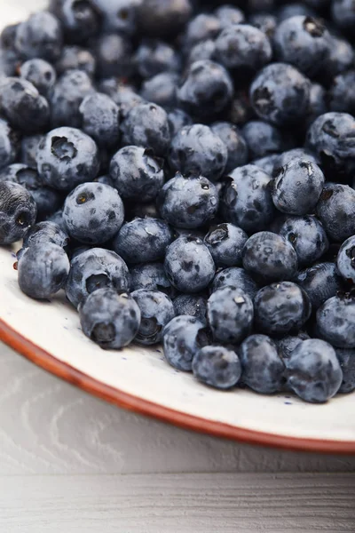 Close up view of plate with delicious blueberries on white wooden table — Stock Photo