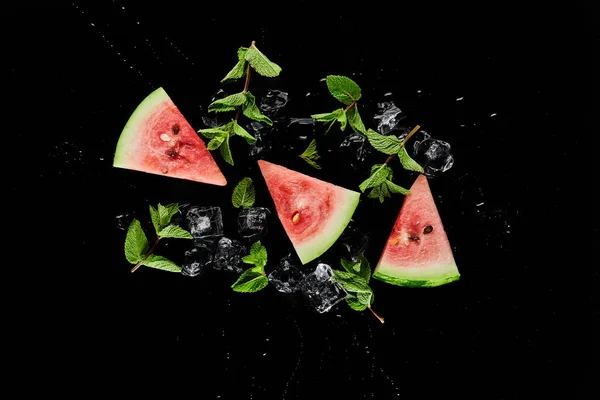 Draufsicht auf rote Wassermelonenscheiben mit Minze und Eis isoliert auf schwarz — Stockfoto