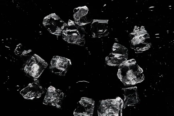 Вид сверху на таяние прозрачных освежающих кубиков льда, изолированных на черном — стоковое фото