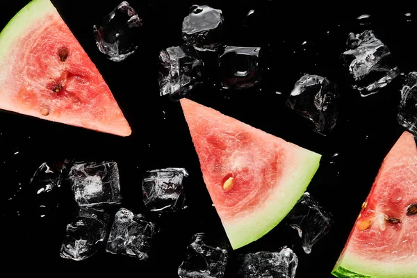 Draufsicht auf rote Wassermelonenscheiben mit schmelzendem Eis isoliert auf schwarz — Stockfoto