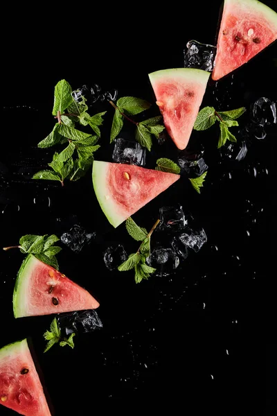 Draufsicht auf rote Wassermelonenscheiben mit Minze und Eis isoliert auf schwarz — Stockfoto