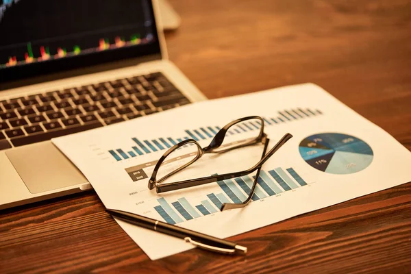 Selektive Fokussierung von Brille, Papier, Stift und Laptop auf dem Tisch — Stockfoto