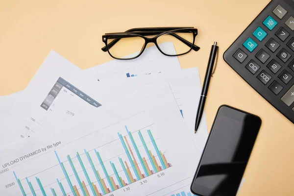 Top view of papers, pen, calculator, smartphone and glasses on table — Stock Photo