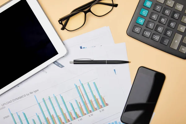 Vue du dessus des papiers, stylo, calculatrice, smartphone, tablette numérique et lunettes sur la table — Photo de stock